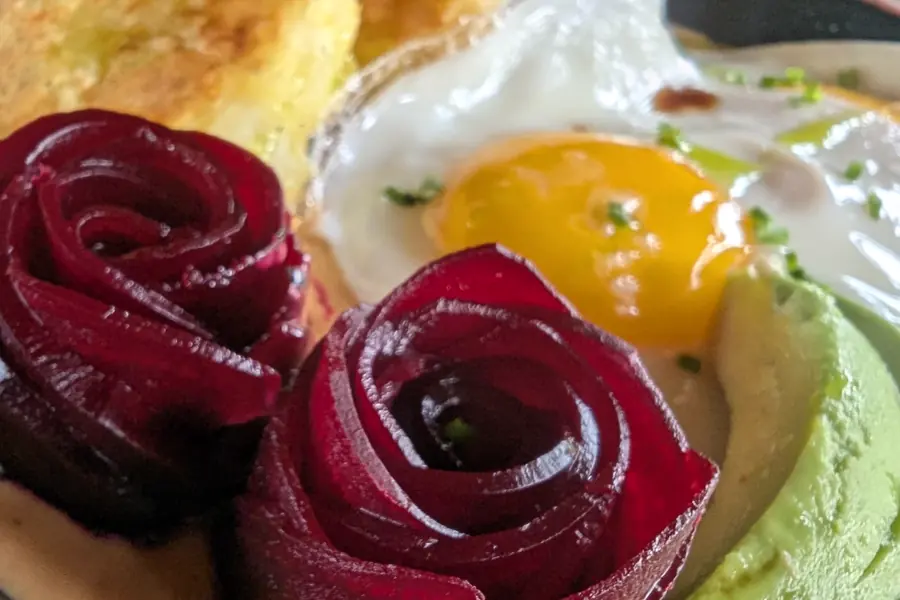 Desayuno de rosas de remolacha, huevo y aguacate sobre pan tostado