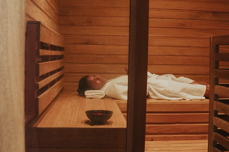 Un huésped acostado dentro de una cabina de cedro para el vapor herbal, en el spa del lodge
